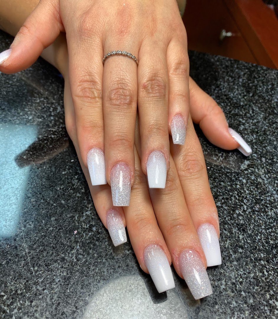 Neatly painted nails on a salon hand display.
