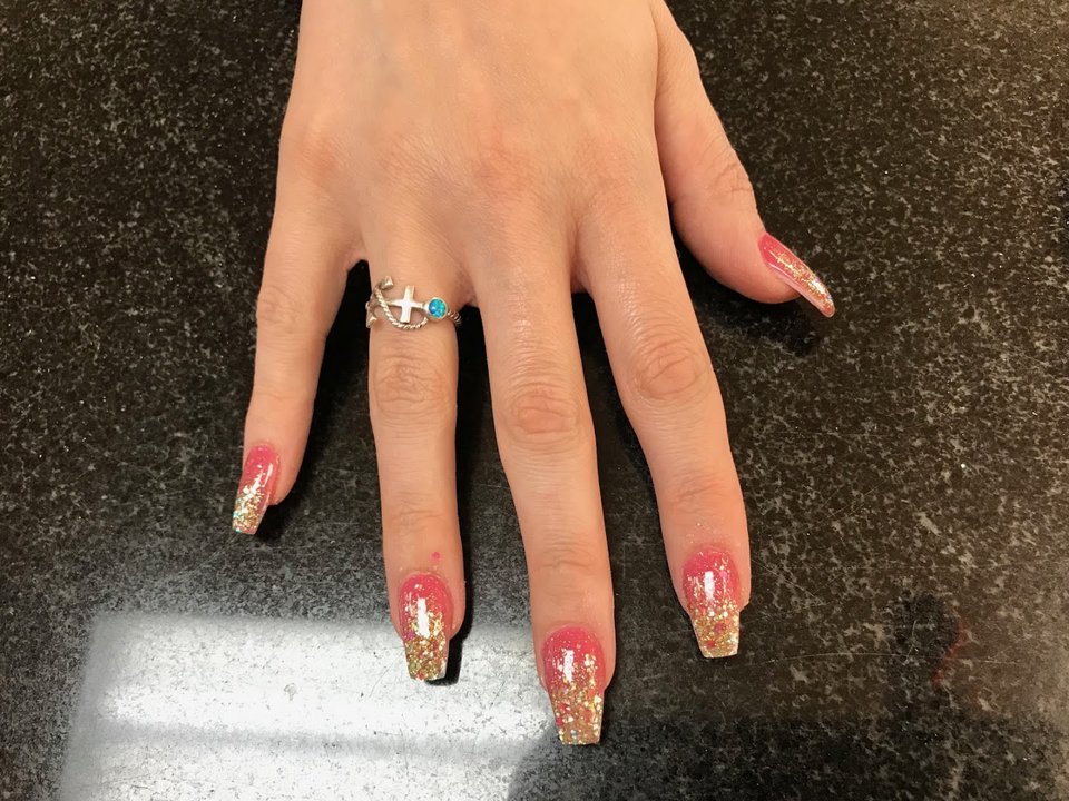 Neatly painted nails on a salon hand display.